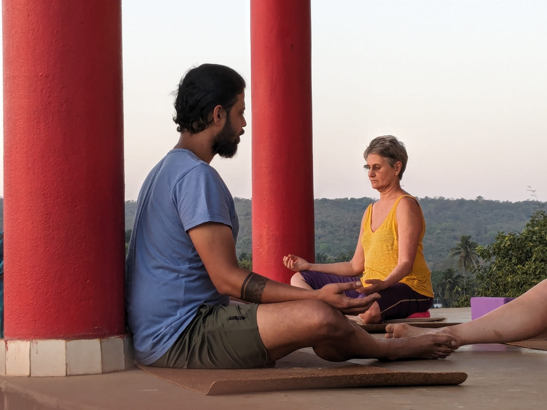 Veer en méditation assise face à une pratiquante, vue sur la vallée.